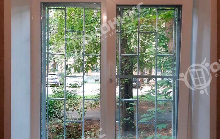 Двухстворчатое пластиковое окно с декоративной раскладкой, установленное в нише. Пример качественного остекления с сохранением эстетики интерьера.