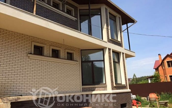 Остекление коттеджа: большие окна с тёмными рамами гармонично вписаны в фасад из облицовочного кирпича. Работа выполнена компанией «Оконикс».
