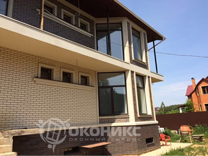 Остекление коттеджа: большие окна с тёмными рамами гармонично вписаны в фасад из облицовочного кирпича. Работа выполнена компанией «Оконикс».